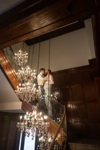 Wedding couple embracing on the chandelier staircase inside Hotel Morgan in Morgantown, West Virginia, photographed by Amberlee Christey.