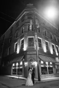 Bride and groom kissing beneath the city lights during a nighttime wedding portrait in downtown Morgantown, West Virginia, photographed by Amberlee Christey.
