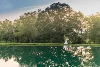 Bride and groom beside a reflective pond at sunset in West Virginia, photographed by Amberlee Christey.