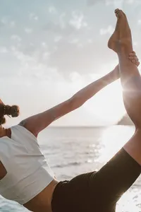opulent-natural-health-woman-doing-yoga-near-the-ocean