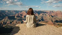 woman-sitting-on-mountain-top-doing-meditation-5548615