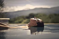opulent-natural-health-woman-with-eyes-closed-resting-head-in-water