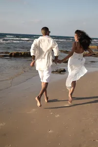 couple-running-together-along-a-sandy-beach-17020663
