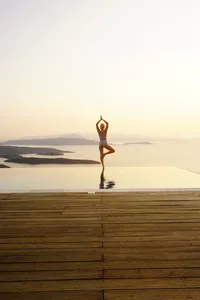 opulent-natural-health-woman-balancing-on-a-pier-at-sunrise