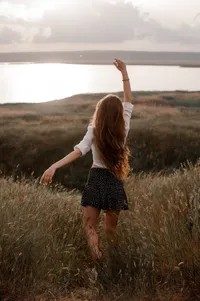 opulent-natural-health-woman-in-polka-dot-skirt-standing-in-field
