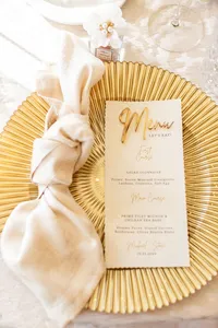 Elegant event place setting with a gold charger, neutral linen napkin and custom dinner menu.