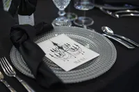 Black corporate event table setting with glass charger, menu, black linens and formal place setting in Phoenix Arizona