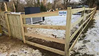 A small, custom wood utility enclosure fence built in a residential yard during the winter in the Baltimore area.