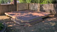 A custom freestanding wood platform deck featuring a built-in lattice privacy screen, installed in a residential Maryland backyard.