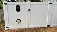 Custom white vinyl privacy gate featuring a built-in dog peek window and heavy-duty black hardware in the Baltimore area, installed by Blue Crab Fence & Home.