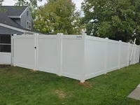 Completed six-foot white vinyl privacy fence with a secure gate installed in Lutherville-Timonium, Maryland. The bright white, low-maintenance PVC panels feature a Blue Crab Fence and Home badge, providing total backyard privacy and security for the residential property.