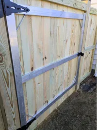 The interior view of a custom wood privacy fence gate reinforced with a heavy-duty metal frame to prevent sagging on a Baltimore region property.
