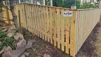 A custom wood privacy fence built to step down and follow the natural slope of a residential yard in Maryland.