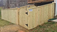 A custom-built wood privacy fence gate featuring heavy-duty black hardware, providing secure access to a Baltimore region backyard.