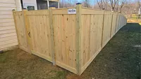 A custom wood privacy fence stepping down a graded residential property line in Ellicott City.