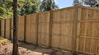 Interior structural view of a heavy-duty wood privacy fence featuring three horizontal backer rails and solid posts in the Baltimore region by Blue Crab Fence & Home.