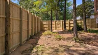 The interior view of a sturdy wood privacy fence showing the heavy-duty posts and rails inside a wooded Maryland backyard.