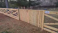 Custom natural wood picket fence and X-braced crossbuck gate installed along a residential backyard in Maryland by Blue Crab Fence & Home.