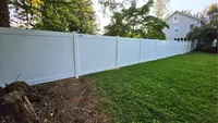 A custom white vinyl privacy fence providing complete backyard enclosure for a residential property in the Baltimore area.