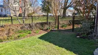 A black aluminum flat-top fence providing a secure, open-view boundary for a landscaped residential backyard in Towson.