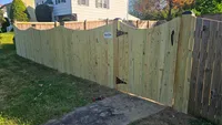 A solid wood privacy fence featuring a secure double drive gate for vehicle access to a Baltimore area property.