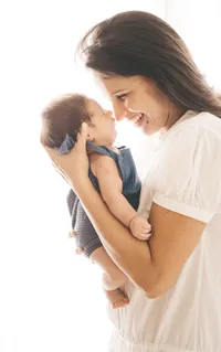 Mom smiling as she holds her newborn