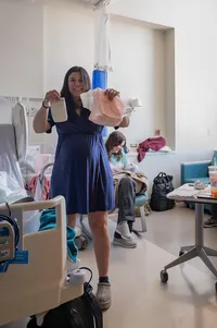 Newly postpartum mother compares her adult diaper with her newborn’s diaper.