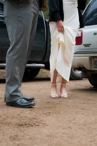 Close-up of a bride and grooms shoes with dirt on their legs after their elopement.