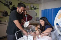 Parents Tend to Their Newborn in the Bassinet.