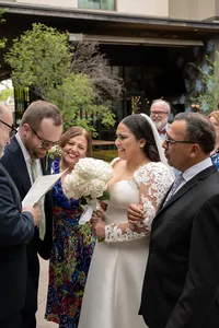 Bride cries as her parents hand her off during her wedding ceremony.