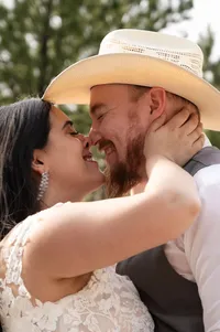 Bride and groom squishing their faces together and smiling.