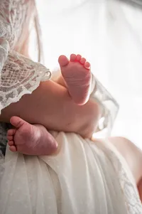 Tiny Newborn Feet in a Parent’s Arms.