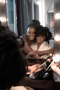 A Joyful Embrace at the Dressing Room Mirror.