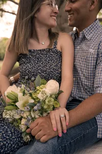 An Engagement Ring Beside a Rose Bouquet.