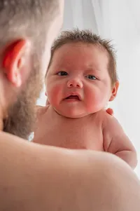 A Newborn Looks Toward Their Father.
