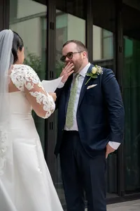 Groom covers his mouth with emotion as his bride reads her vows.