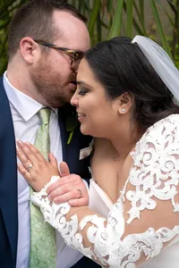 Bride and Groom hold each other close as he whispers in her ear.