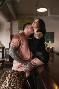 Man kissing woman's neck on counter.