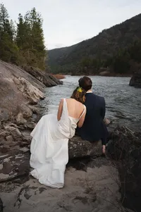 Bride rests her head on Groom as they look down the river after their elopement.