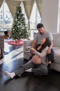 Expecting parents smile at each other as they examine their baby's sonogram photos.