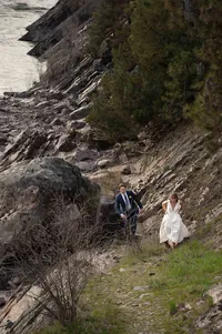 Bride and Groom running up a hill near the river after their elopement.