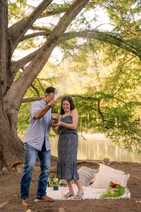 Couple popping champagne after getting engaged.