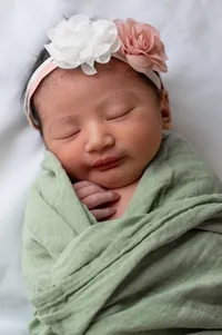 A Sleeping Newborn in a Green Blanket.