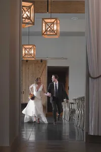 Bride and groom running through an empty wedding venue before their reception.