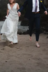 Close-up of Bride and Groom's feet as they run in the sand.
