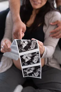 Expecting parents admiring their baby's sonogram photos.