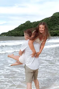 Man carrying his fiancé over his shoulder.