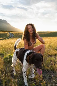 Woman laughs as her dog photobombs her boudoir session.