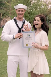 Bride and groom flash their rings and marriage certificate outside of the famous Austin courthouse after their elopement.