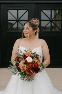 Bride wearing soft glam bridal makeup with glowing skin and lashes with a romantic updo hairstyle